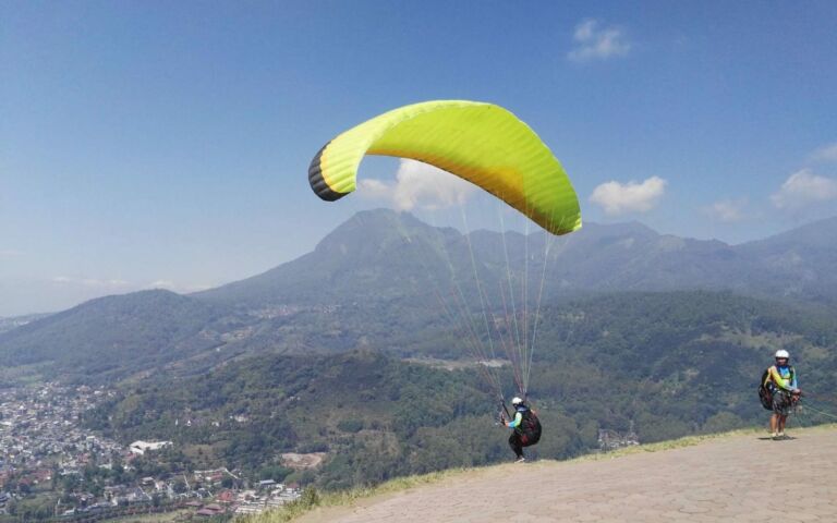 Melintasi Langit Sambil Menikmati Keindahan Alam: Sensasi Unik Paralayang dengan Latar Pemandangan Hijau Melintasi Langit Sambil Menikmati Keindahan Alam: Sensasi Unik Paralayang dengan Latar Pemandangan Hijau